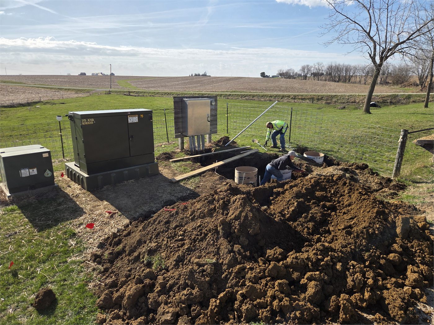 Kuhl Electric field crew installing underground electrical infrastructure beside farm equipment